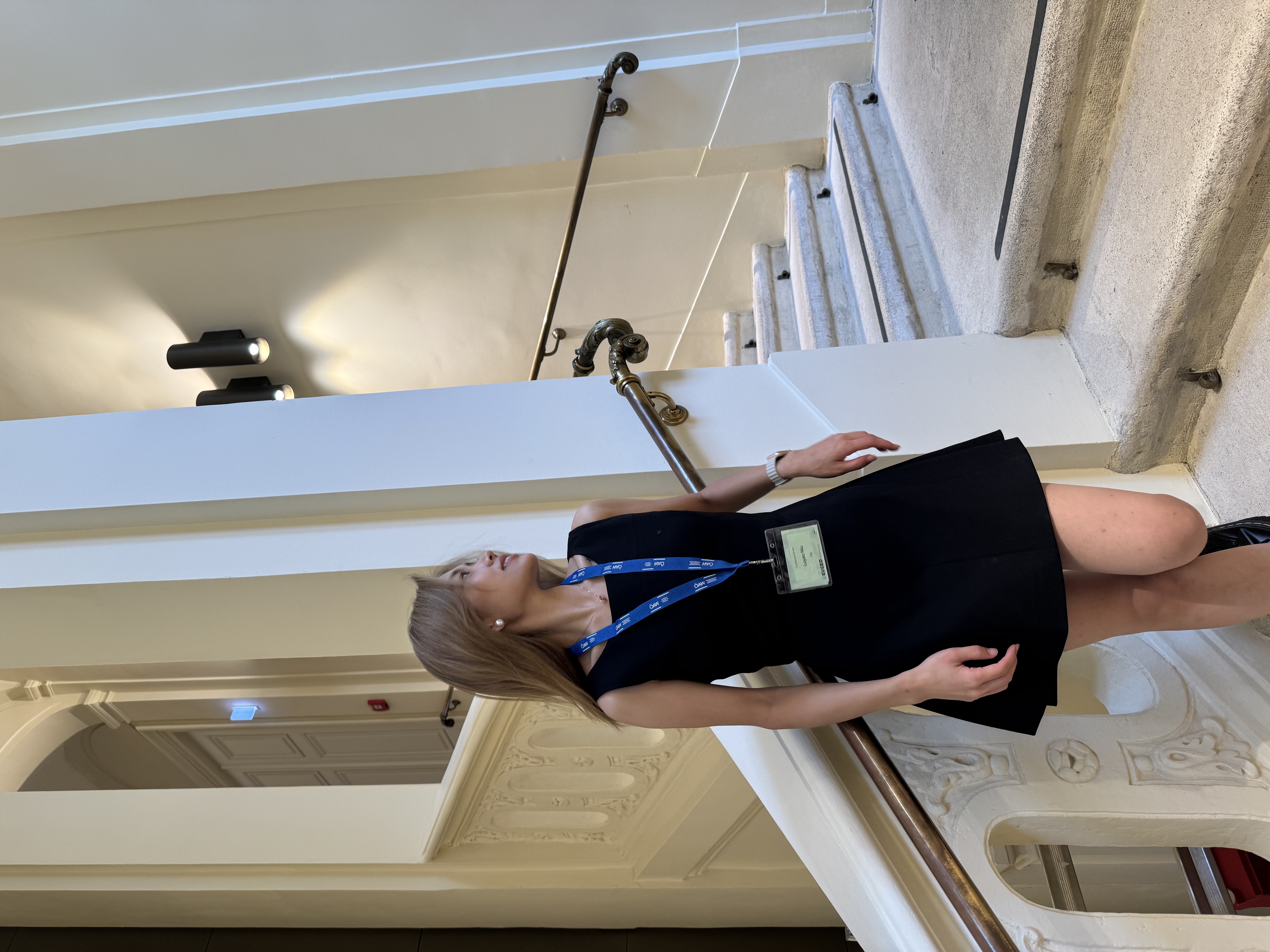 Portrait of Luyao Niu standing beside an indoor staircase